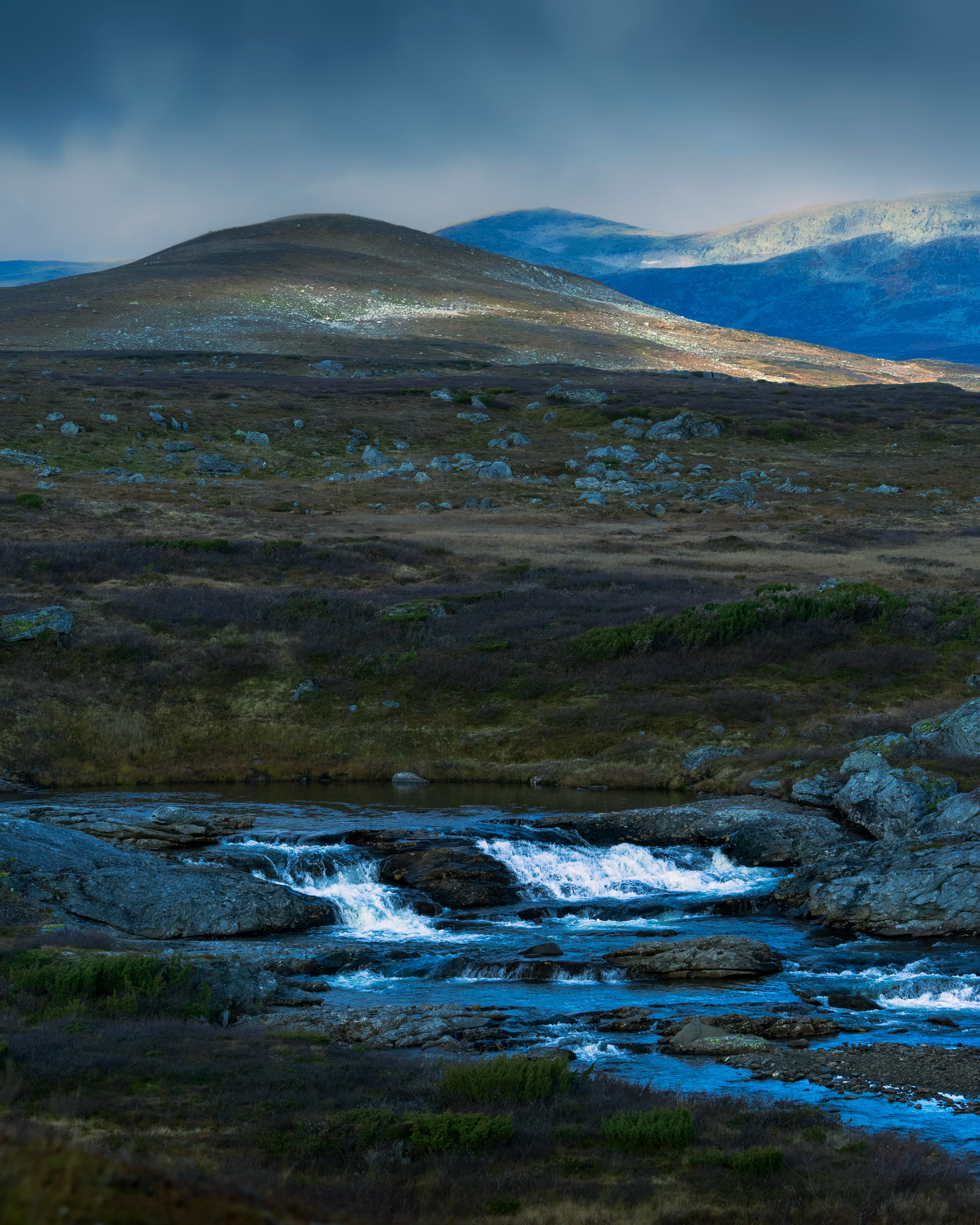 Rocky mountain landscape with a small fast-moving stream in the foreground